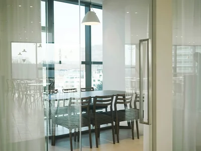 Comedor separado por paneles de vidrio de piso a techo