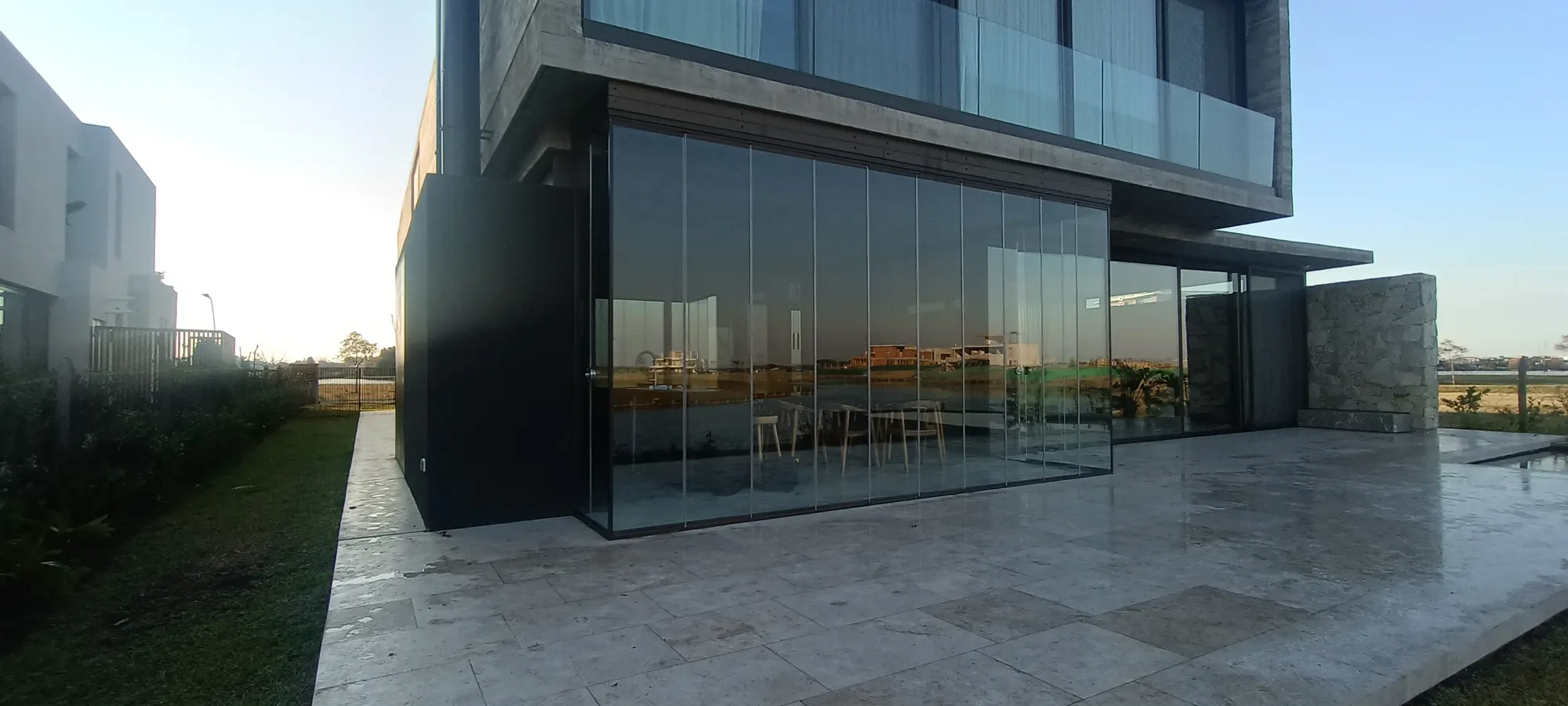 Galería cerrada con vidrio en la planta baja de una casa moderna
