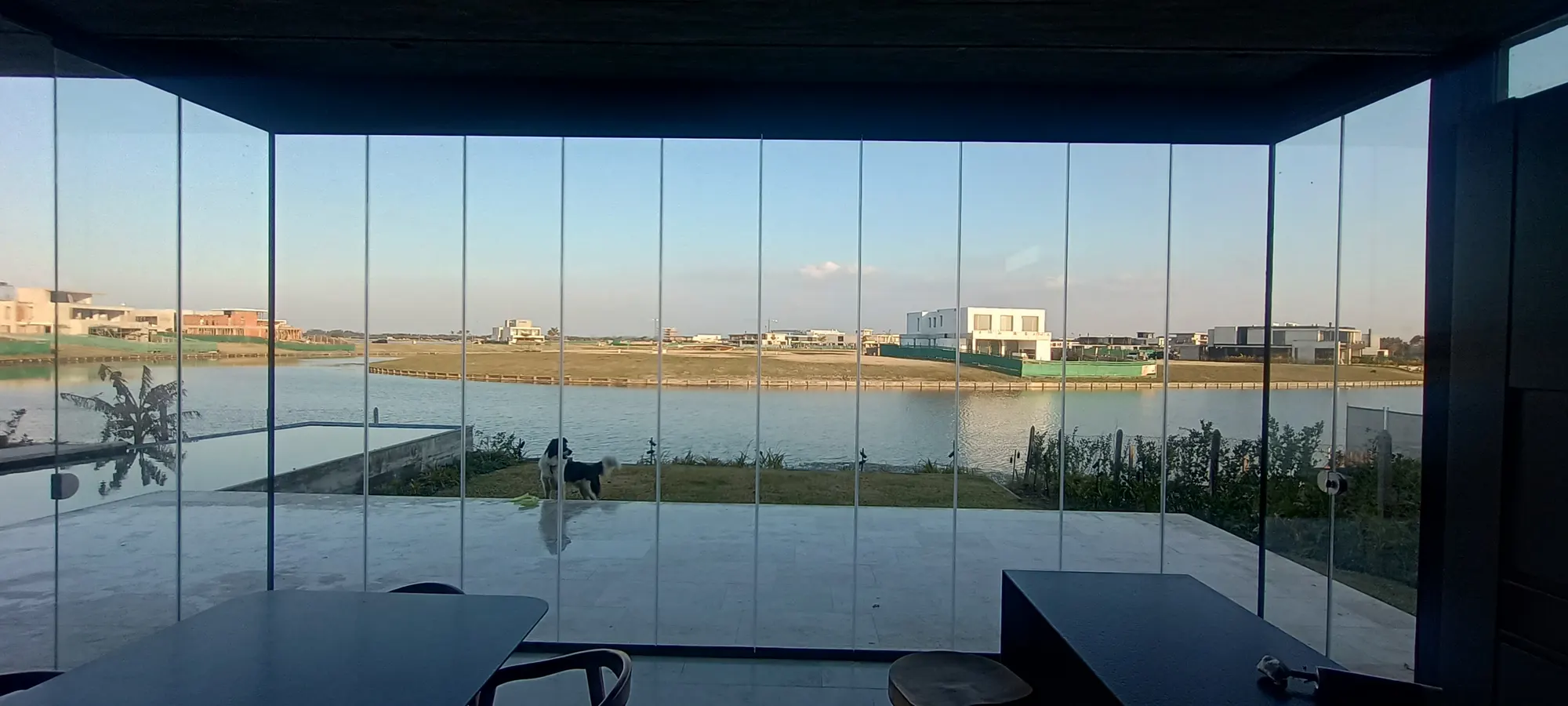 Vista a la laguna desde una galería cerrada con paños de vidrio